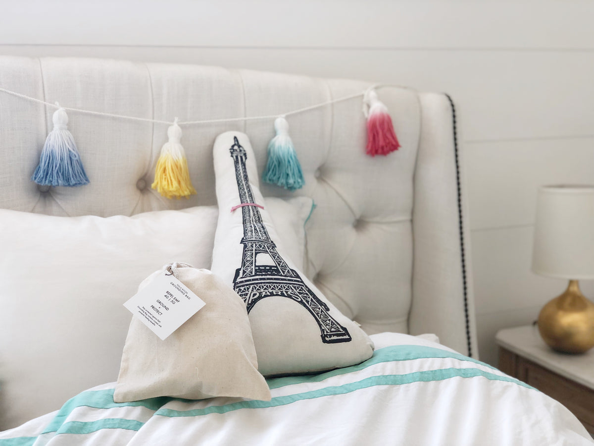 Child sleeping peacefully with Deep Sleep Grounding Bag on bed for EMF protection and better sleep quality