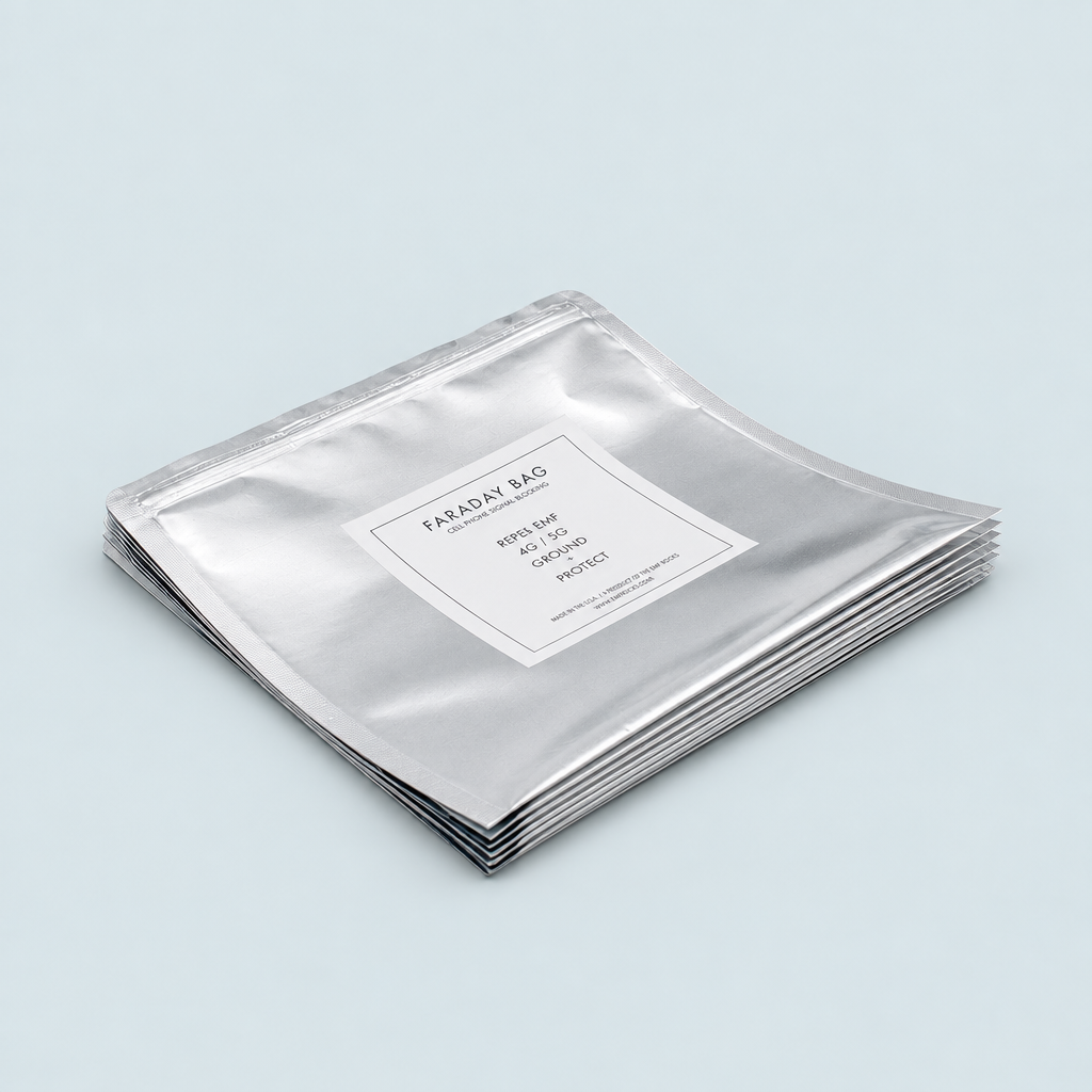 Stack of silver EMF Rocks Faraday Bags with a white product label on a pale blue-gray background