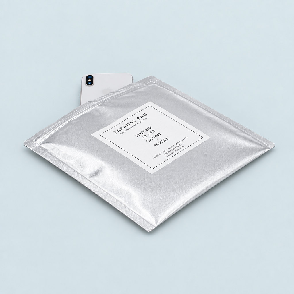 Silver EMF Rocks Faraday Bag with a light-colored phone partly visible behind it on a pale blue-gray background